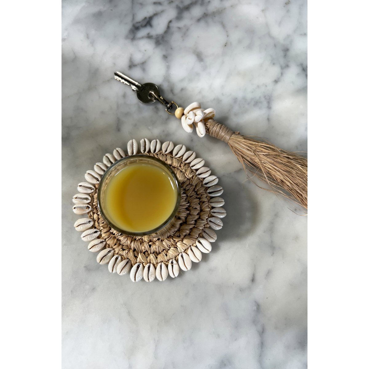 De Raffia Kauri-schelp sleutelhanger