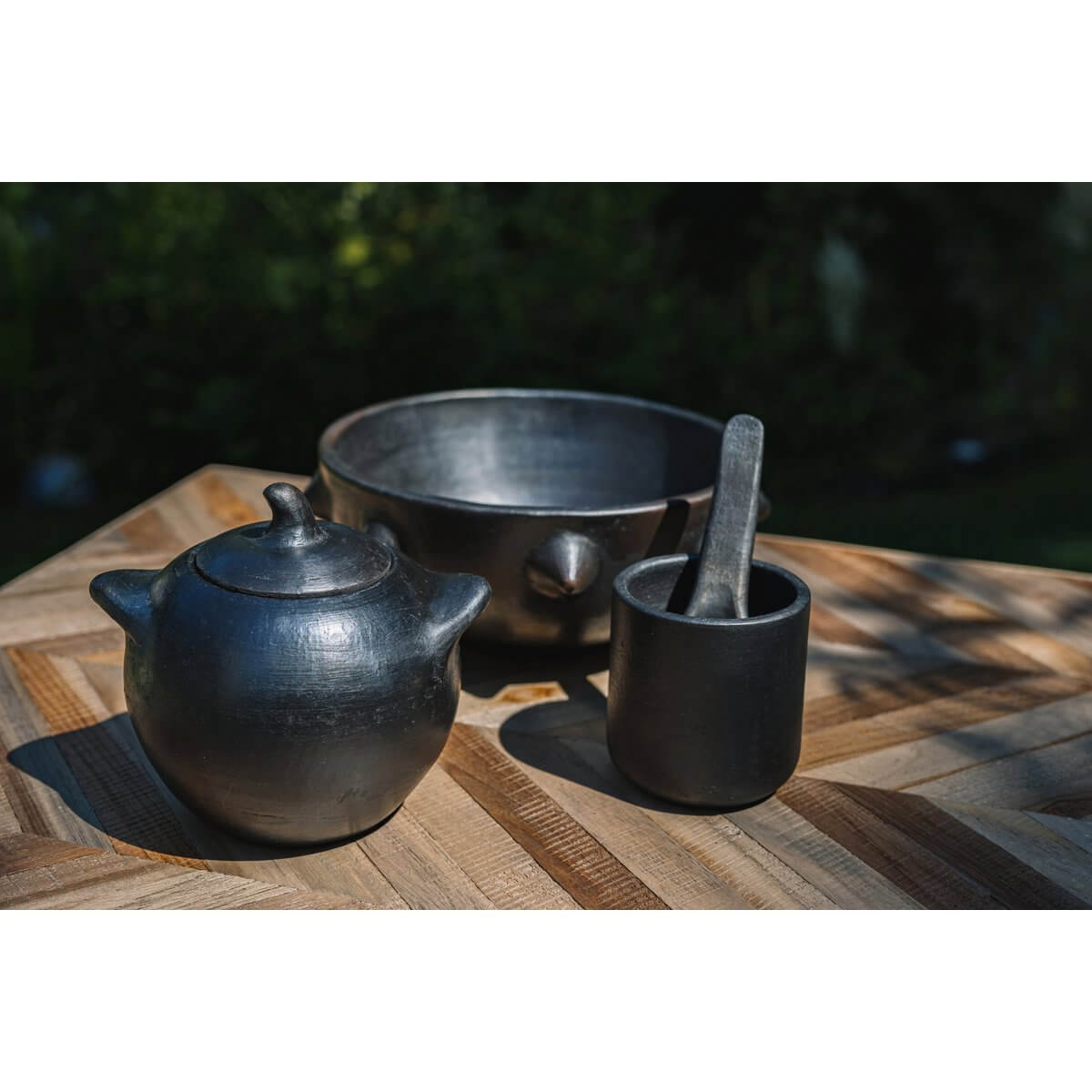 Zwart servies van de Burned-collectie op houten tafel, met De verbrande beker voor opvallende presentatie van gerechten.