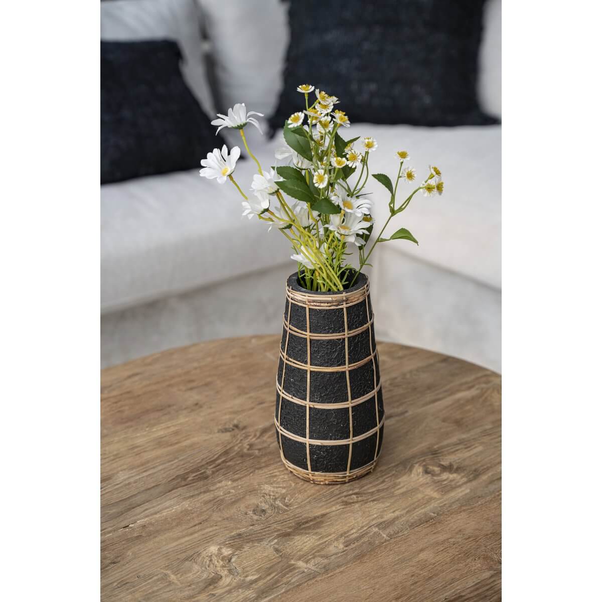 The Cutie Vaas - Zwart Naturel - L met bloemen, perfect voor woonkamerdecoratie met terracotta en raffia-details op houten tafel.