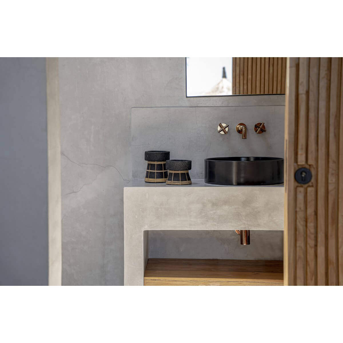 De Serene Kaarsenhouder - Zwart Naturel - S in moderne badkamer, gemaakt van terracotta met rotanrooster, op wastafel